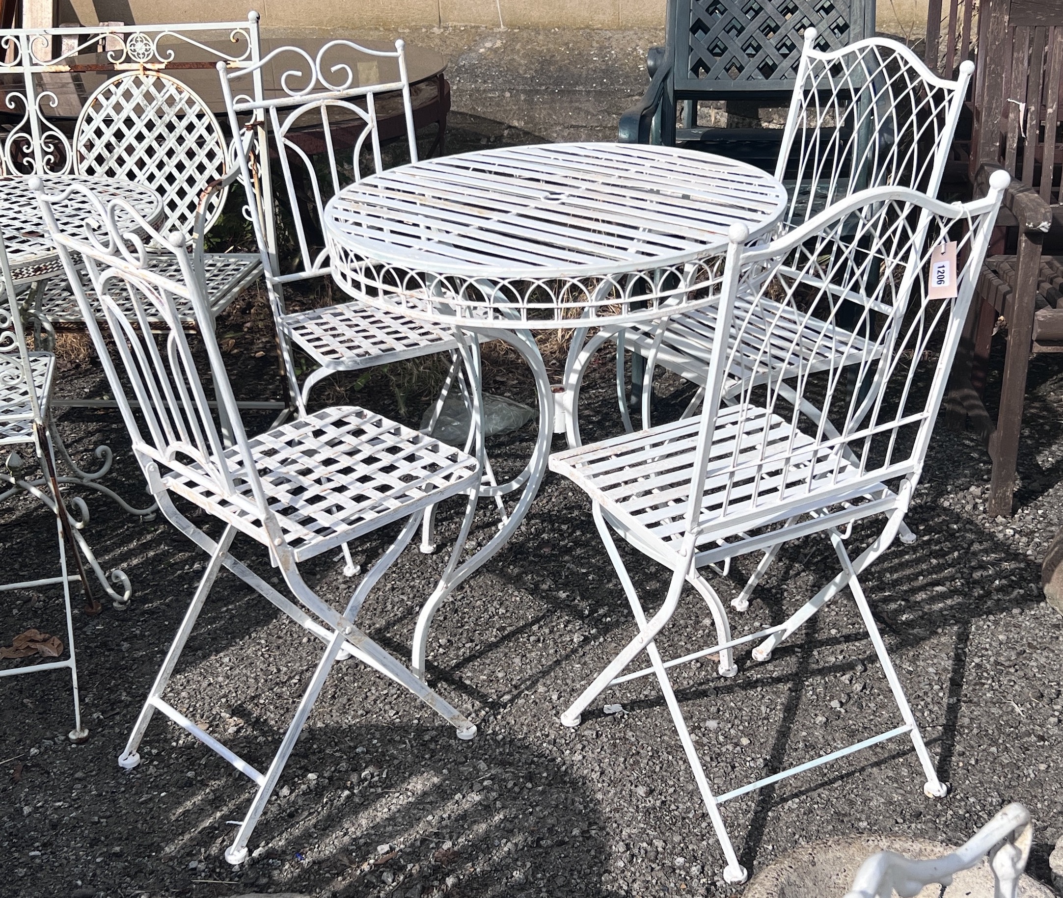 A circular painted aluminium garden table, diameter 74cm, height 77cm, and four folding garden chairs